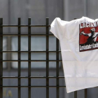 Una camiseta reivindicativa cuelga de la verja del Ministerio de Industria en una manifestación. R. P. VIECO