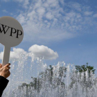 Un guía de la firma WPP en Londres atrae a los congregados con el logo de la compañía.