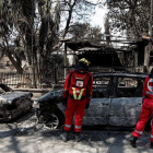 Tres bomberos buscan supervivientes entre coches y edificios calcinados. KOLESIDIS