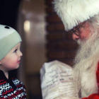 Un niño entrega su carta a Papá Noel.