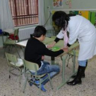 Uno de los niños autistas del Centro Docente Autismo de León recibe instrucciones de una profesora