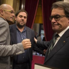 Raül Romeva, Oriol Junqueras y Artur Mas se saludan al terminar la sesión matinal del Parlament de ayer.