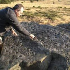 Juan Carlos Campos señala los petroglifos que encontró en las tierras de La Somoza