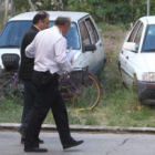 Un agente en camisa traslada desde la comisaría a uno de los imputados ante el juez, acusados tambié
