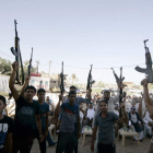 Voluntarios chiítas para combatir con las fuerzas iraquíes alzan sus armas en Kerbala.