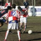 Jugadores de los dos equipos disputan el balón durante el partido