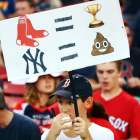 Un joven sostiene una pancarta con dibujos de 'emojis' en el partido de béisbol entre los New York Yankees y los Boston Red Sox de este domingo.