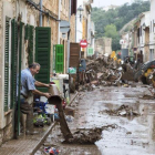 Vecinos de la localidad mallorquina de San Llorenc tratan de quitar el barro y el agua acumulados en las casas y las calles a causa de las inundaciones del martes.