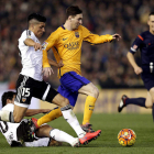 Leo Messi se lleva el balón ante el acoso de los jugadores del Valencia Enzo Pérez y Parejo
