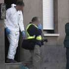 Dos agentes de la Policía Judicial abandonan la casa en la que se encontró el cuerpo de Isabel Rodríguez.
