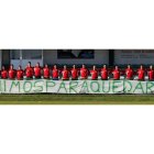 Jugadores y cuerpo técnico del Astorga posan detrás de una pancarta en la que se lee ‘Vinimos para quedarnos’, deseo que espera cumplir el domingo el plantel verde