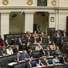 Los parlamentarios belgas, con la imagen de pantalla que publica los resultados de la votación aprobada de la eutanasia para los menores, en febrero del 2014.