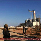 Dos yihadistas frente a la central eléctrica tomada en Sirte.