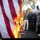 Manifestantes queman la bandera.