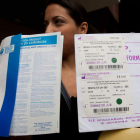 Una mujer afectada por los implantes PIP muestra los certificados de dicho producto.