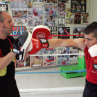 Alfredo Arrojo, a la izquierda, enseña el arte del boxeo a un joven púgil. MARCIANO PÉREZ