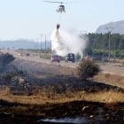 Un helicóptero refresca el terreno para evitar el rebrote de las llamas