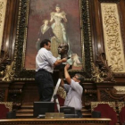 Dos trabajadores municipales retiran el busto del rey Juan Carlos I, en julio.