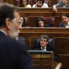 Mariano Rajoy en la tribuna de oradores es escuchado por Pablo Iglesias desde su escaño. JAVIER LIZÓN
