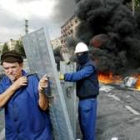 Un par de trabajadores de Izar en Bilbao preparan barricadas para seguir con sus protestas