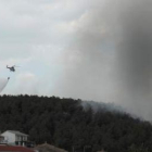 Un helicóptero descarga agua sobre el pinar cercano al barrio alto de Alija.