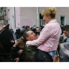 Un hombre y una mujer se abrazan tras la liberación de los arrestados de Odesa, este domingo.