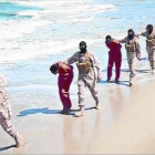 Imagen del vídeo del EI con yihadistas encapuchados conduciendo a sus víctimas por una playa de Libia.