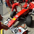 Mecánicos de Ferrari preparan el coche de Fernando Alonso.