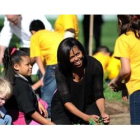 Michelle Obama, en el huerto de la Casa Blanca con una niña.