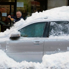 Un hombre limpia de nieve su coche atrapado por la nieve en una céntrica calle de Ávila, el pasado domingo.