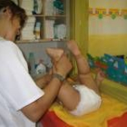 Una monitora atiende a un bebé  en el centro infantil ubicado en la calle Limonar de Cuba