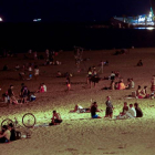 Varios jóvenes se divierten en la playa de la Barceloneta, en Barcelona, anoche, tras el cierre de discotecas. QUIQUE GARCÍA