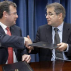 Antonio Silván y Jordi Valls se entrechan las manos tras la firma del acuerdo, ayer en Barcelona
