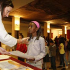 Una pequeña recoge el diploma que acredita su asistencia a los cursos.