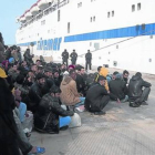 Grupos de inmigrantes esperan a ser trasladados desde Lampedusa a Sicilia.