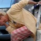 Una mujer llora junto a la vivienda de Alzira en la que se produjo el tiroteo