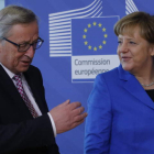 El presidente de la Comisión Europea, Jean-Claude Juncker, saluda a Ángela Merkel.