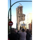 Varios curiosos fotografían el edificio siniestrado el sábado