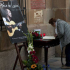 Una mujer firma en el libro de condolencias frente a un fotografía de Paco de Lucía en Algeciras.