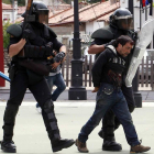 Uno de los dos detenidos en Ciñera, con sangre en la cabeza, es conducido por los antidisturbios.