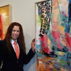La artista onubense Carmen Gómez posa junto a dos de las obras de la exposición. CUEVAS