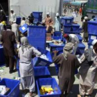 Operarios ordenan unas urnas en un almacén de la Comisión Electoral.