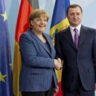 La canciller Merkel estrecha la mano del primer ministro moldavo Filat.