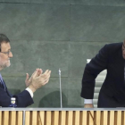 Mariano Rajoy aplaude a Luis de Guindos en el acto de presentacion de su libro de memorias.