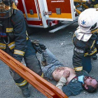 Un bombero ayuda al herido por una pelota de goma en el ojo, el jueves.