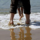 Un padre juega con su hija en la playa de la Concha. JAVIER ETXEZARRETA