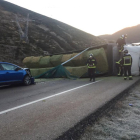 Bomberos del parque de León junto al camión volcado y el turismo que colisionó por alcance contra él.