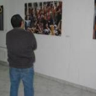Un hombre observa varias de las fotografías de la exposición