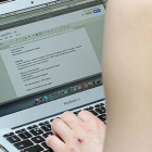 Una mujer consulta su correo electrónico en su portátil.