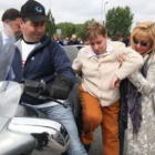 Isabel Carrasco ayuda a subirse a una moto a una discapacitada durante una jornada festiva en el Sag